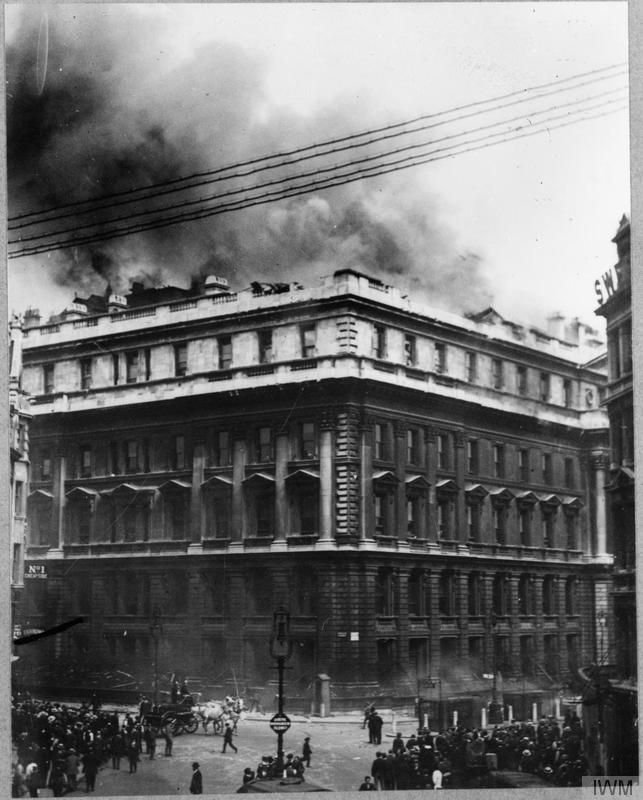 In the aftermath of the second German daylight Gotha raid on London, crowds watch as smoke pours from the roof of the Central Telegraph Office, struck by a 100 lb bomb, 7 July 1917