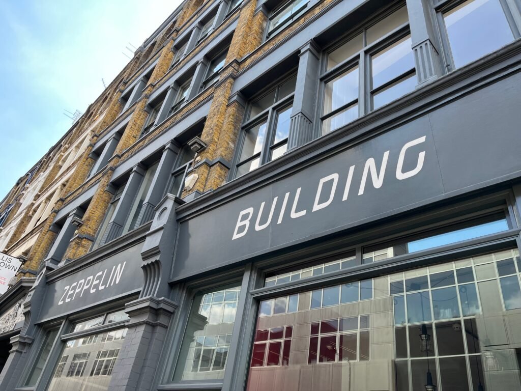 Exterior of a multi-storey building with yellow brick and gray accents featuring the sign "ZEPPELIN BUILDING."