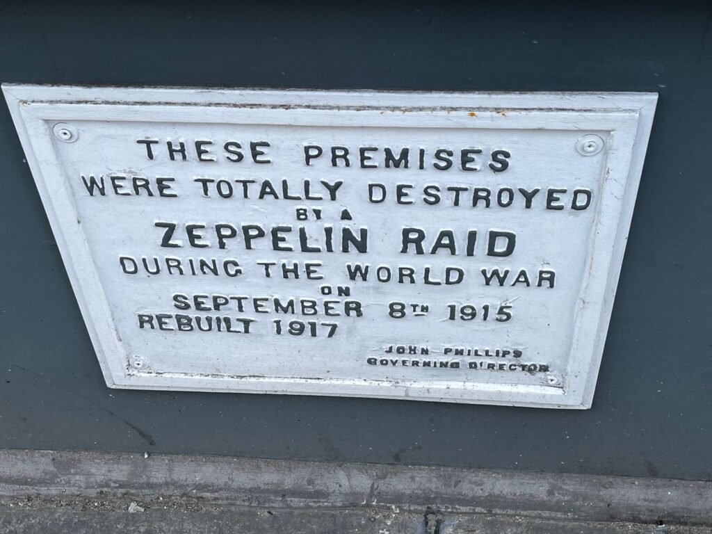 White plaque with text about premises destroyed by a Zeppelin raid in World War I.