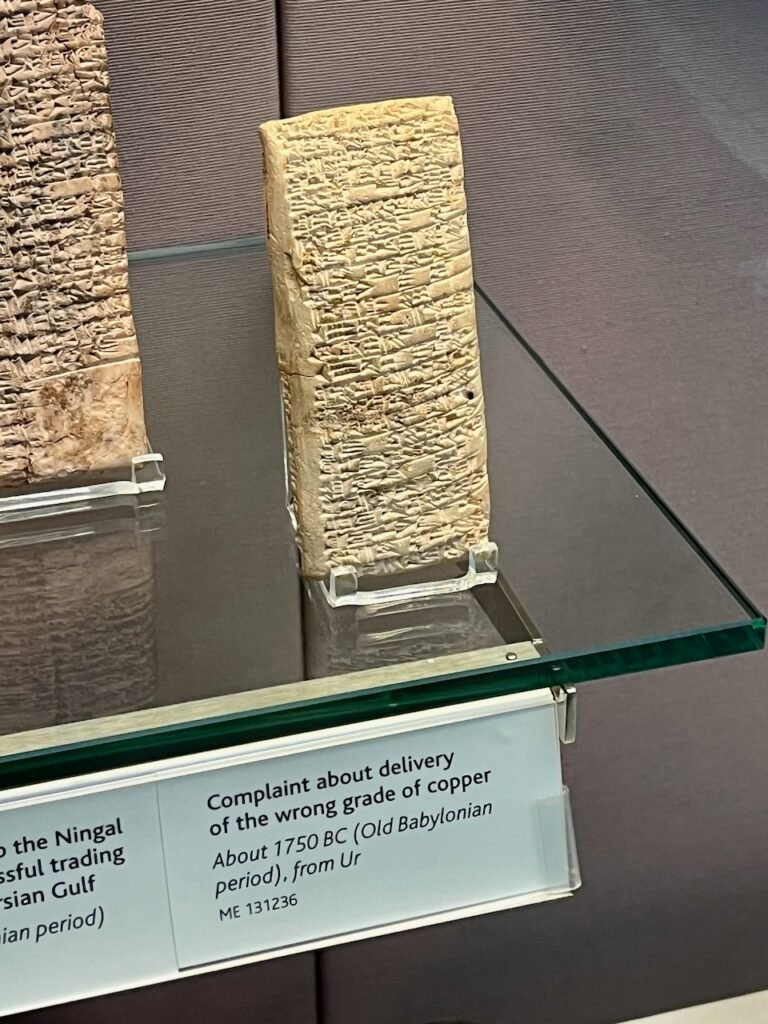 Clay tablet with cuneiform script on display in a museum.