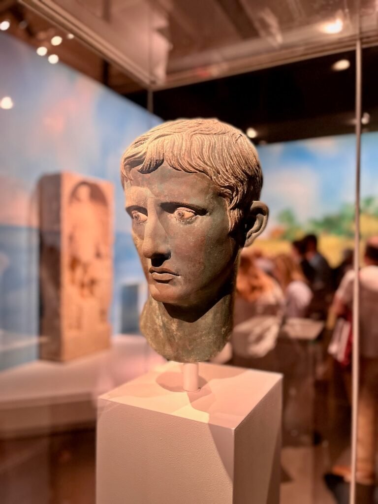 Classical bronze sculpture head displayed in a museum.