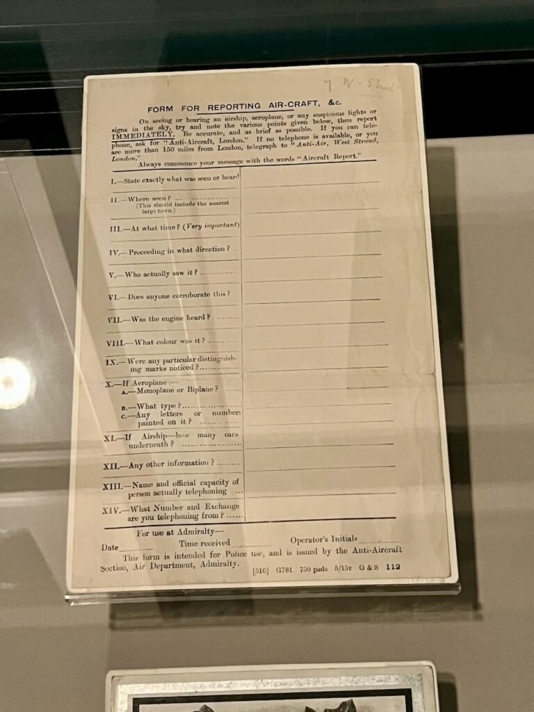 Old aircraft reporting form displayed in a glass case with structured questions and faded text.