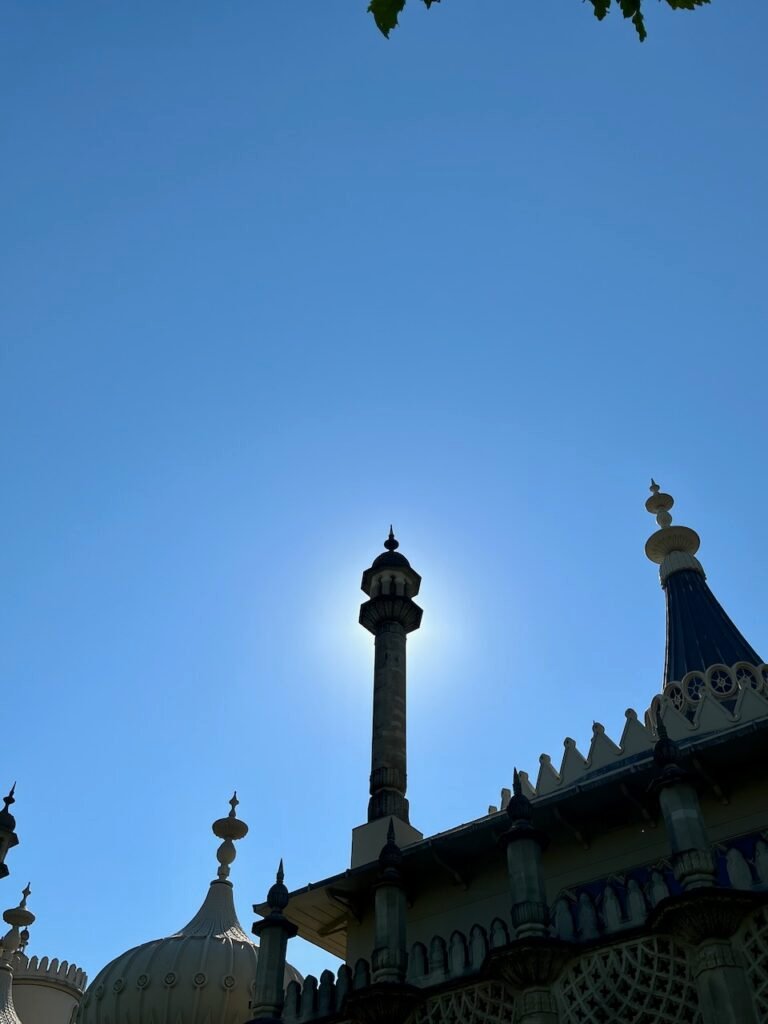 Ornate building with spires and domes silhouetted against a clear blue sky.