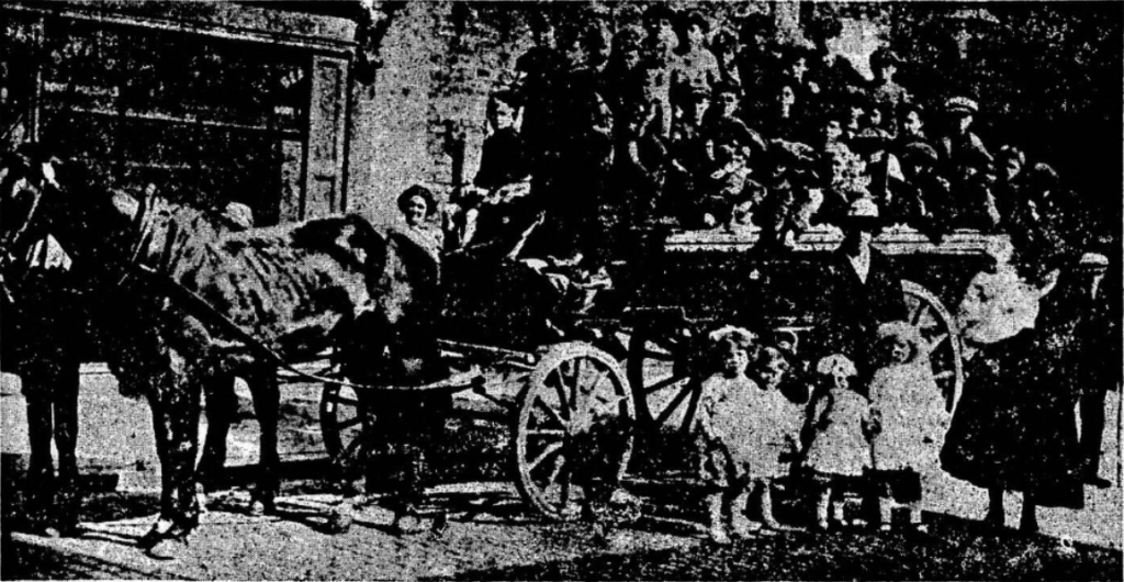 Horse-drawn carriage with people seated and standing children in front.