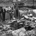 Mutual aid in an air raid Stoke-on-Trent September 1940. A man, his wife and their nine children were in an Anderson shelter and escaped injury when their home was wrecked by a bomb.